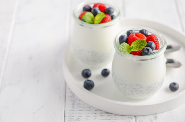 Chia seed pudding with fresh berries on a white wooden table Premium Photo