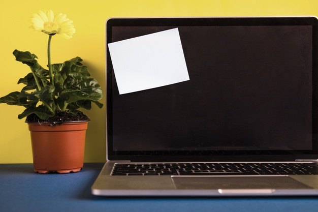 Laptop with post-it note on opened lid Free Photo