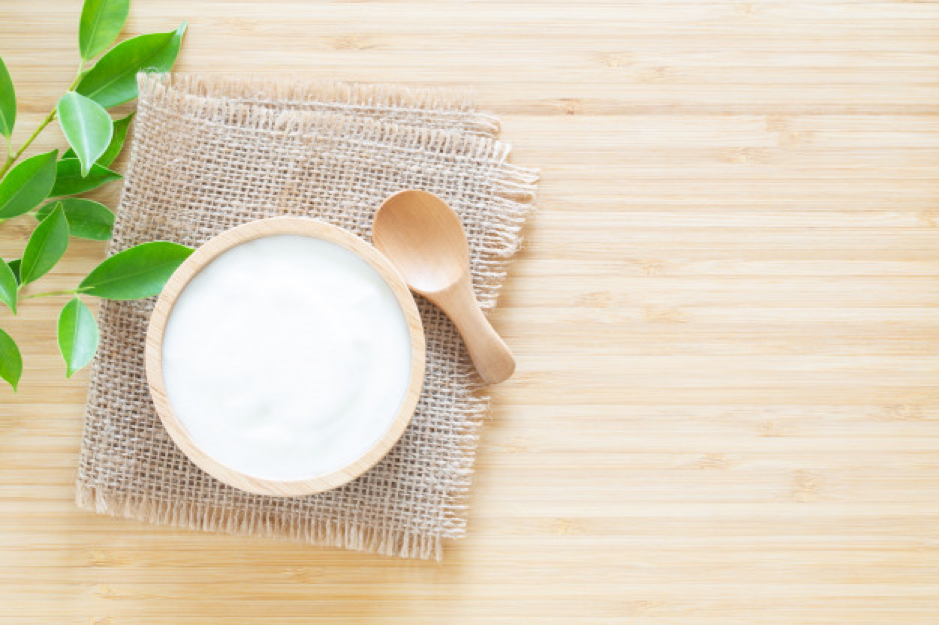 Yogurt in wood bowl on white wooden table Premium Photo